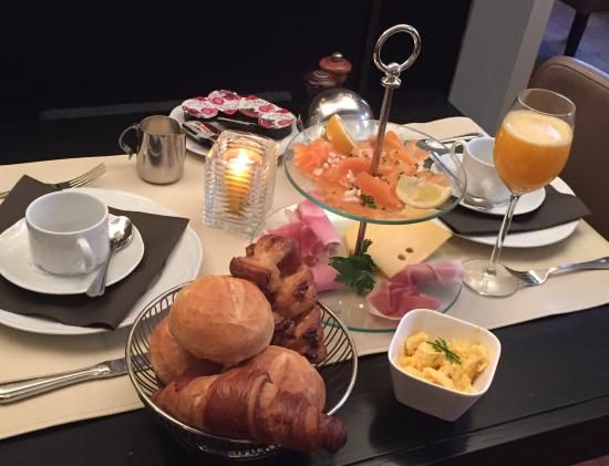 Ontbijt met croissants, zalm, ham en vers sinaasappelsap
